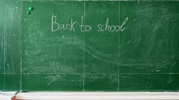 Green chalk blackboard written Back To School with white chalk