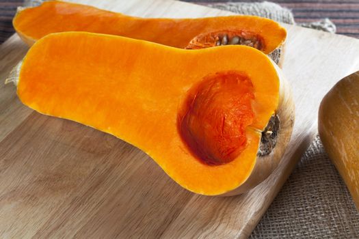 Butternut squash cut in half on cutting board