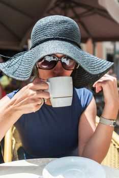 Girl drinking coffee at street cafe