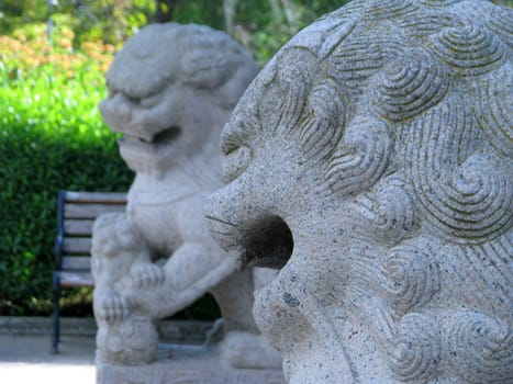 Two granite lions ina garden in Santa Lucija, Malta.