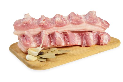 Raw bacon with ribs on a wooden cutting board. Isolated on white.