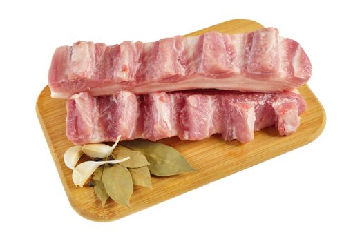 Raw bacon with ribs on a wooden cutting board. Isolated on white.