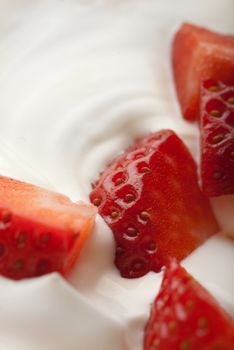 Whipped cream engulfing red chopped strawberries