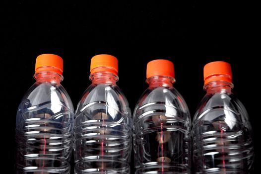 four closed plastic bottles isolated on black  background