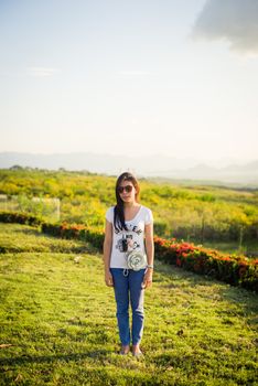 asian girl standing on grass field with sunlight and sky on the background