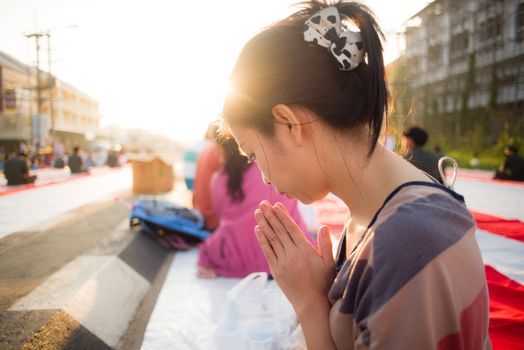 Asian girl put the palms of the hands together in salute with sun light