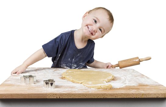 young child making cookies on small wooden desk