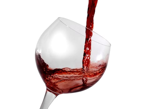 red wine being poured in a tilted wine glass isolation on white