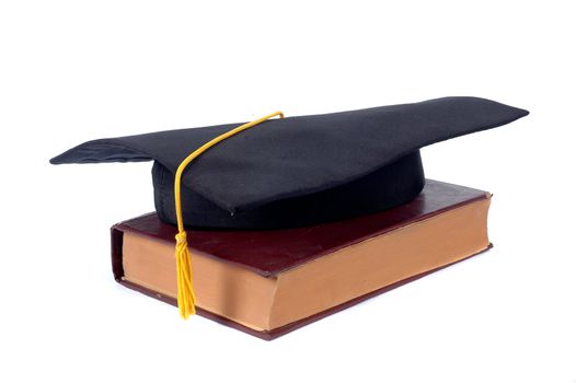 graduate cap and old book isolated on white background