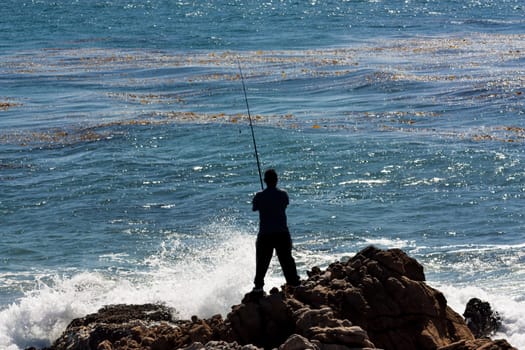 Man Fishes Against the Crashing Ocean Waves at Leo Carillo State Beach