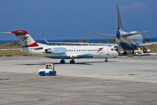 Fokker 70 of Austrian Arrows (Tyrolean Airways) parked at Rhodes airport, picture are shot from the departure hall at Rhodes airport.