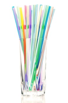 Colorful cocktail straws in glass on a white background