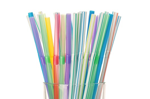 Colorful cocktail straws in glass on a white background