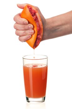 Glass of fresh grapefruit juice and hand with half of grapefruit on white background