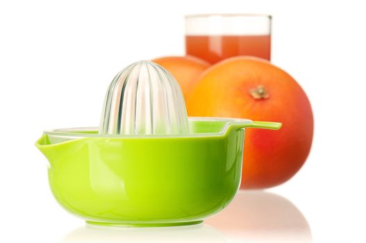 Glass of fresh grapefruit juice, juicer and grapefruit fruits on white background