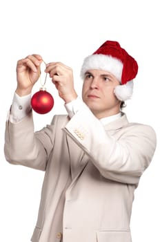 Portrait of handsome man in santa hat with red bauble for christmas firtree on white background