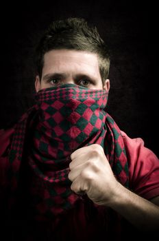 Dangerous hooligan with covered face showing a fist