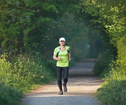 Older woman running on countryside path