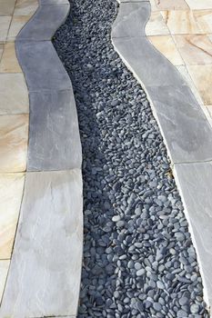 a garden patio design with slabs and pebbles