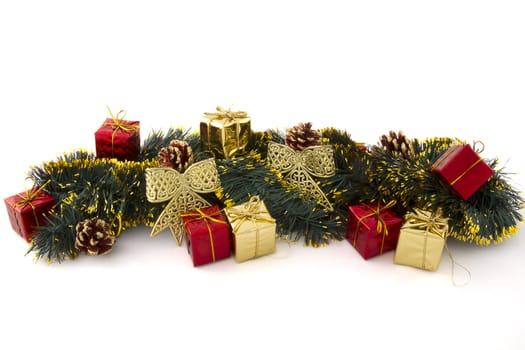 arrangement of Christmas decorations (gifts, tinsel, cones, ribbons) on a white background