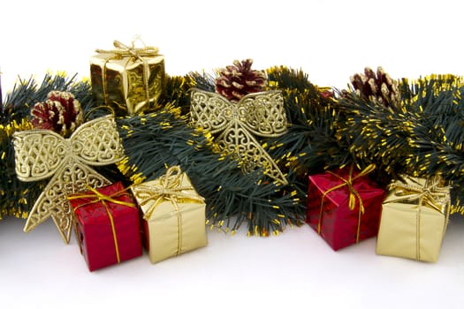 arrangement of Christmas decorations (gifts, tinsel, cones, ribbons) on a white background