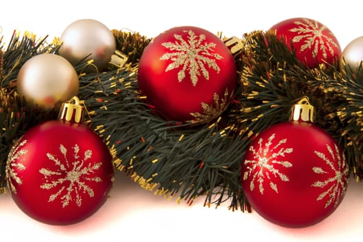 arrangement of Christmas decorations (red and gold balls, tinsel) on a white background