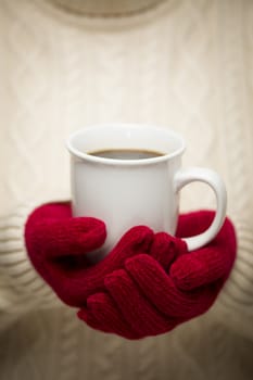 Woman in Sweater with Seasonal Red Mittens Holding a Warm Cup of Coffee.