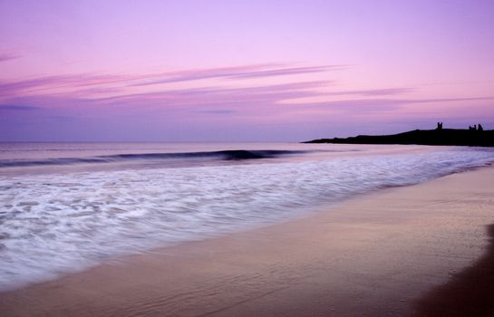 Dunstaburgh Castle at sunset from the beach