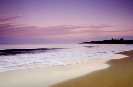 Dunstaburgh Castle at sunset from the beach