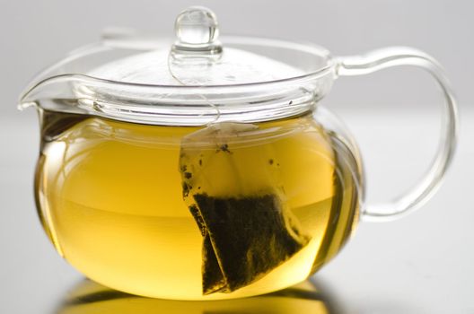 Glass tea pot with herb tea bag and herb tea