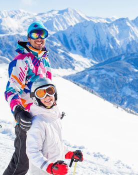 Happy smiling girl in ski goggles and with her father, Zellertal, Austria. Focus on the girl