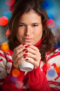 Young woman drinking a hot drink from a white mug