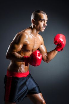 Boxer with red gloves in dark room