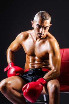Boxer with red gloves in dark room