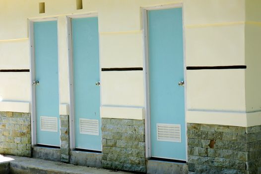three blue plastic doors in public lavatories