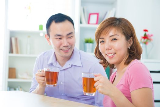 Attractive asian couple enjoying tea/coffee at home