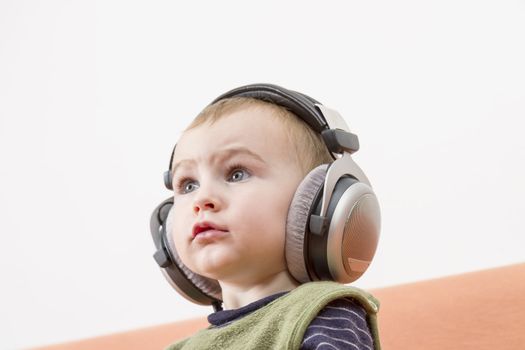 young child on couch with big earphone