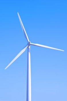 Wind turbine set against a blue sky
