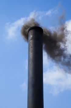 Metal chimney pumping out thick black smoke
