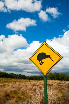 Kiwi crossing road sign against cloudy sky at New Zealand