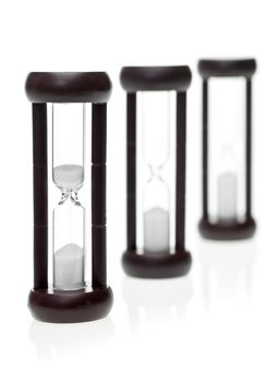 Time is running out concept - three sand timers on white background