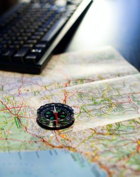 Compass and map on a table with keyboard, very shallow DOF