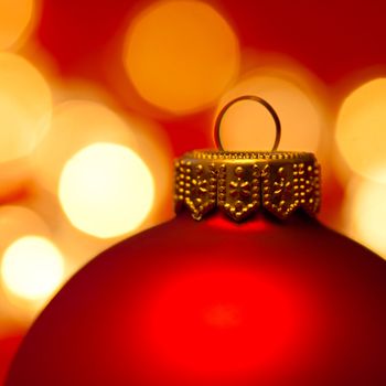 Red Christmas bauble with blured lights in background, very shallow DOF