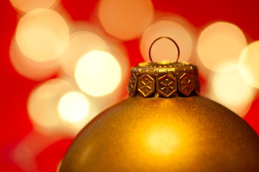 Golden Christmas bauble with blured lights in background, very shallow DOF