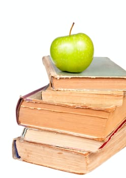 Stack of old books with green apple