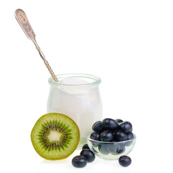 Old-fashioned yogurt jar with spoon and fruits on white background