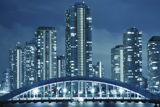 cold toned cityscape of night Tokyo, modern buildings at Tsukishima district and Eitai bridge