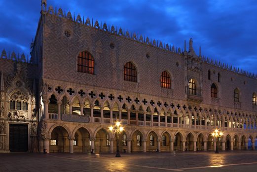 Facade of The Doge's Palace in Venice, lit up by the light of the lampposts in the early morning.