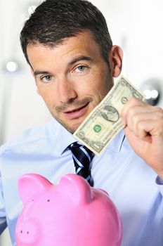 businessman matting a coin in the piggy-shaped pink pig