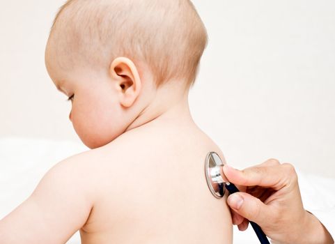 Children's doctor exams infant with stethoscope